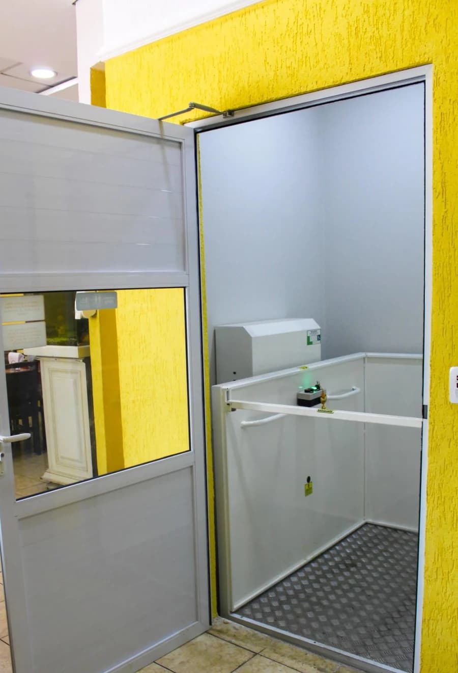 Plataforma de acessibilidade instalada com cabine e porta de pavimento.